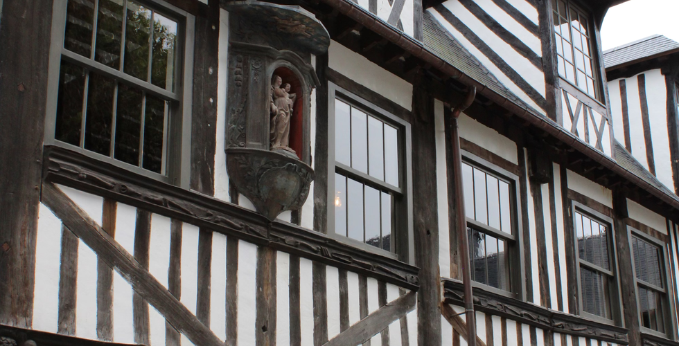 Timbered Walls of Plague Cemetery with Statue with Madonna and Child