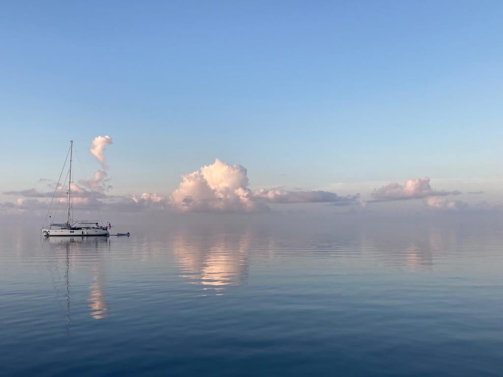 A single sailing yacht resting on calm reflective water