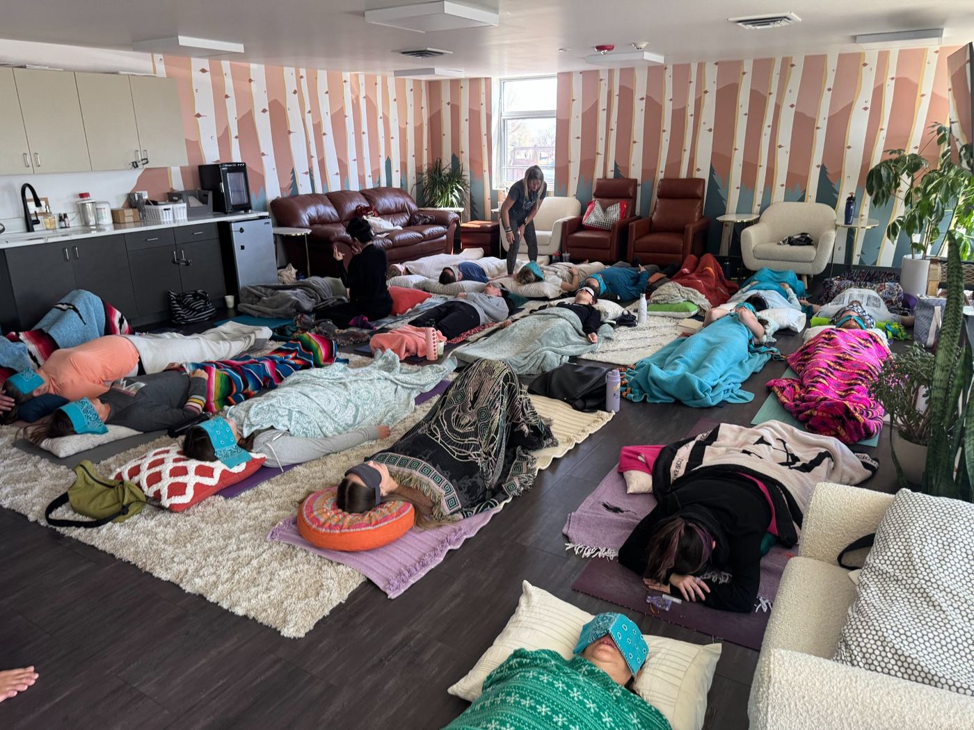 Group breathwork training with participants resting on mats