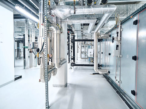 Bodenbeschichtung einer moderne Gebäudetechnik:  Komplexes Rohrsystem und Anlagentechnik im Technikraum