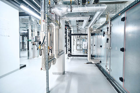 Bodenbeschichtung einer moderne Gebäudetechnik:  Komplexes Rohrsystem und Anlagentechnik im Technikraum