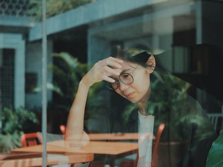 Woman looking sad through a window