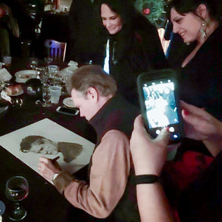 Randy Travis signing original portrait of Randy, created by Corey Frizzell, owned by Barrett Hobbs (Nashville Palace)