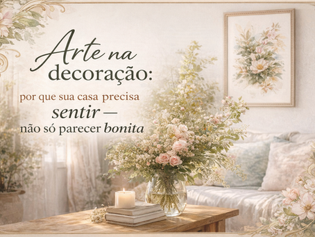 Imagem de sala de estar clara e aconchegante com arranjo de flores sobre mesa de madeira, vela acesa e quadro de arte botânica na parede, com o texto “Arte na decoração: por que sua casa precisa sentir — não só parecer bonita”.