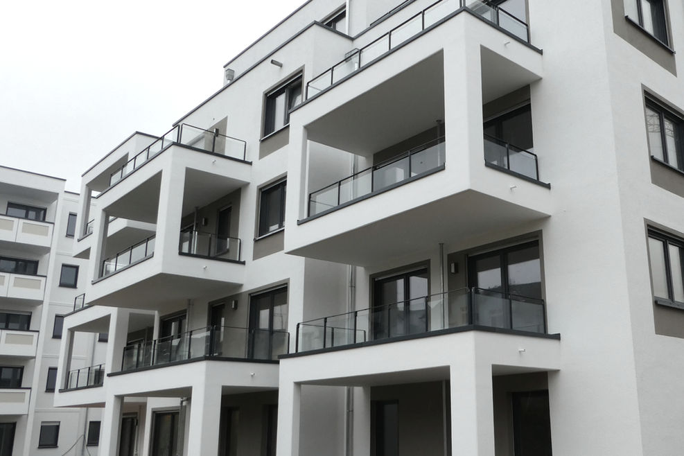 vorspringende kubusartige Balkone mit Glasbrüstungen