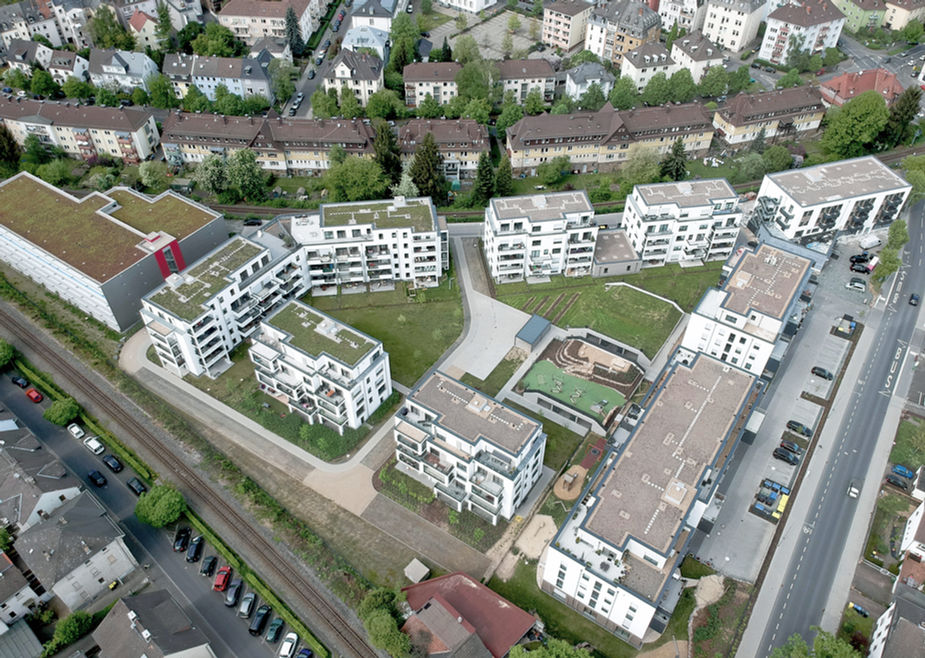Vogelperspektive auf das ganze Stadtquartier. Begrünte Dachflächen.