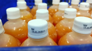 Continuous Inkjet (CIJ) printer marking expiration dates and batch codes on beverage bottles in high-speed bottling production line with non-contact printing technology