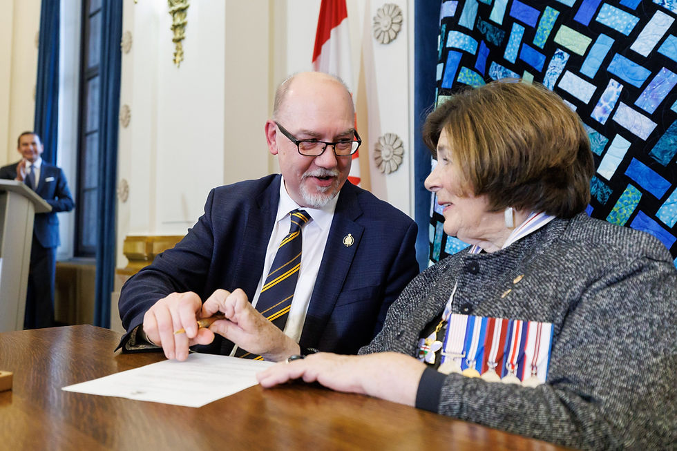 Two people signing a document at a desk
