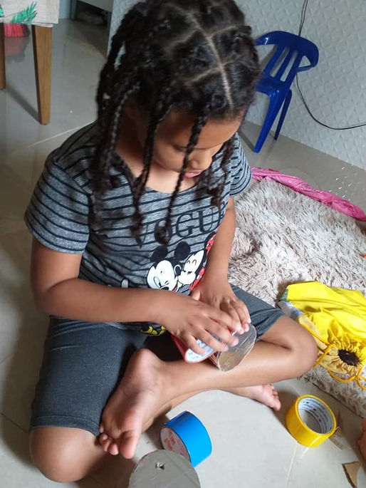 Brenda, aluna do 3° ano B, construindo brinquedo com materiais recicláveis