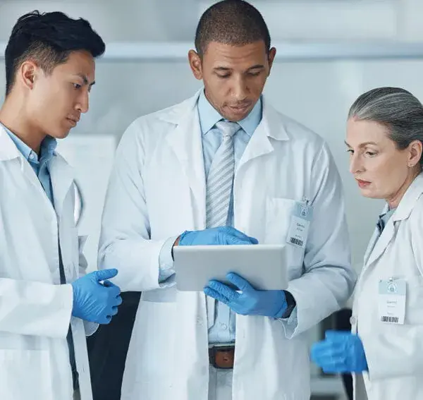 Lab consultants reviewing SOPs on a tablet for CLIA and CAP compliance planning in Santa Monica, California, Laboratory Consulting Services.