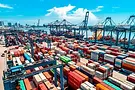 Aerial view of a busy international shipping port with colorful cargo containers and crane