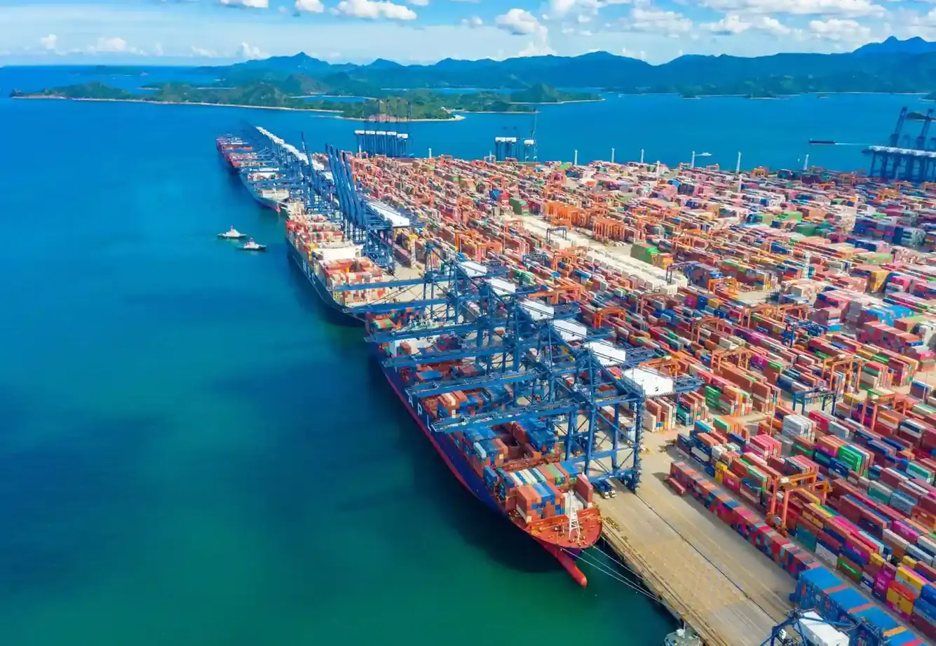 Cargo ship docked at port with cranes and containers — Tiger Freight freight services in Malibu Beach CA