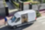 White Sprinter van loaded with multiple packages during local delivery, representing efficient Sprinter van loads for last-mile logistics.