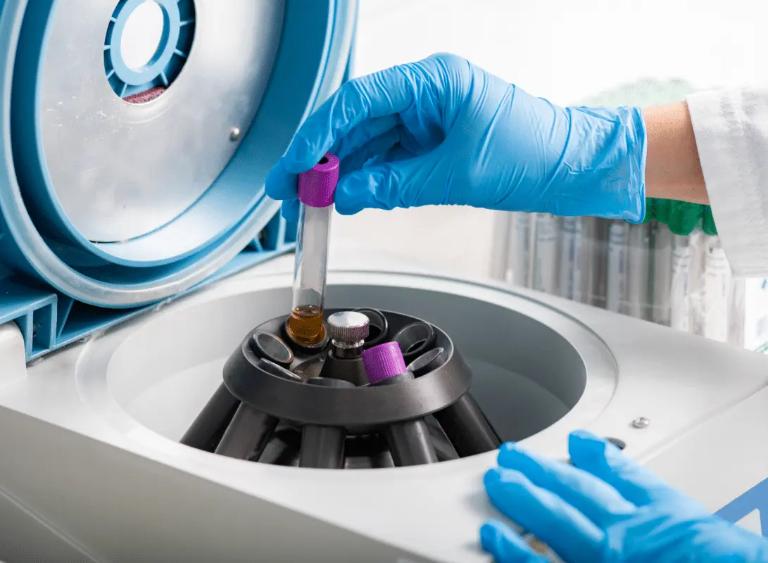 Gloved technician validating a centrifuge and documenting pre-analytical QC for CLIA CAP compliant operations in Palo Alto, California, Laboratory Consulting Services.