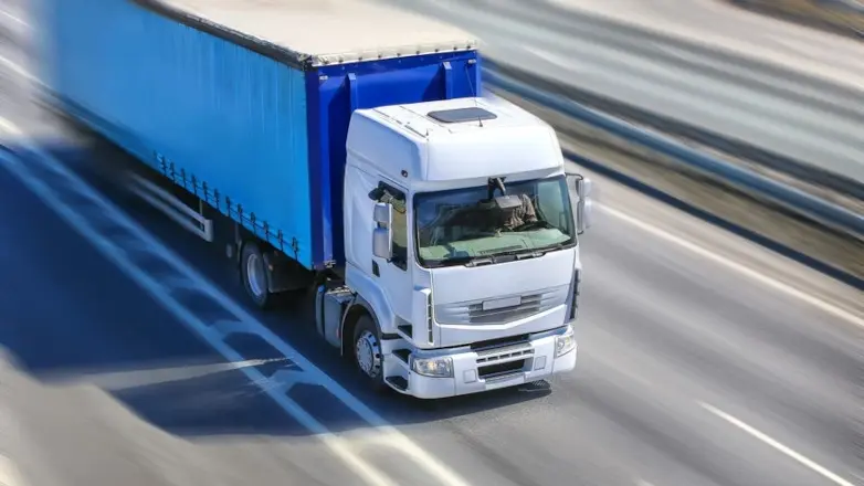 white freight truck with blue trailer on highway in Santa Monica California by Tiger Freight


