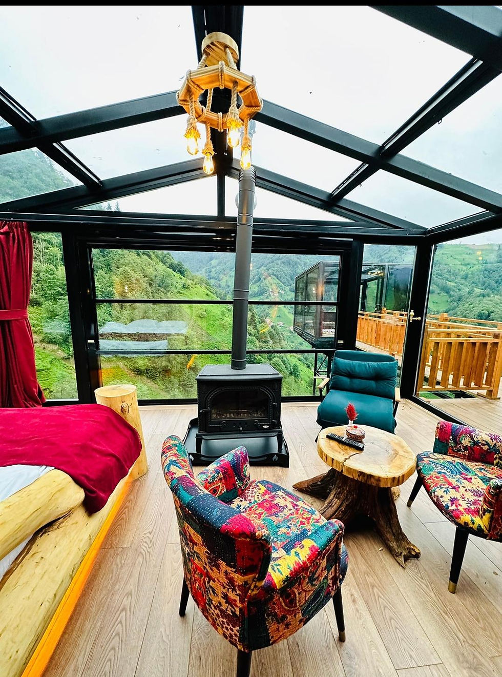 Thumbnail: Glass-walled room with bed, chairs, fireplace, mountain view