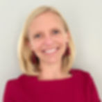 A white woman with shoulder-length blonde hair and a red, square-neck shirt.