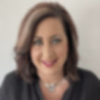 A white woman with shoulder-length brown hair and a black v-neck shirt.