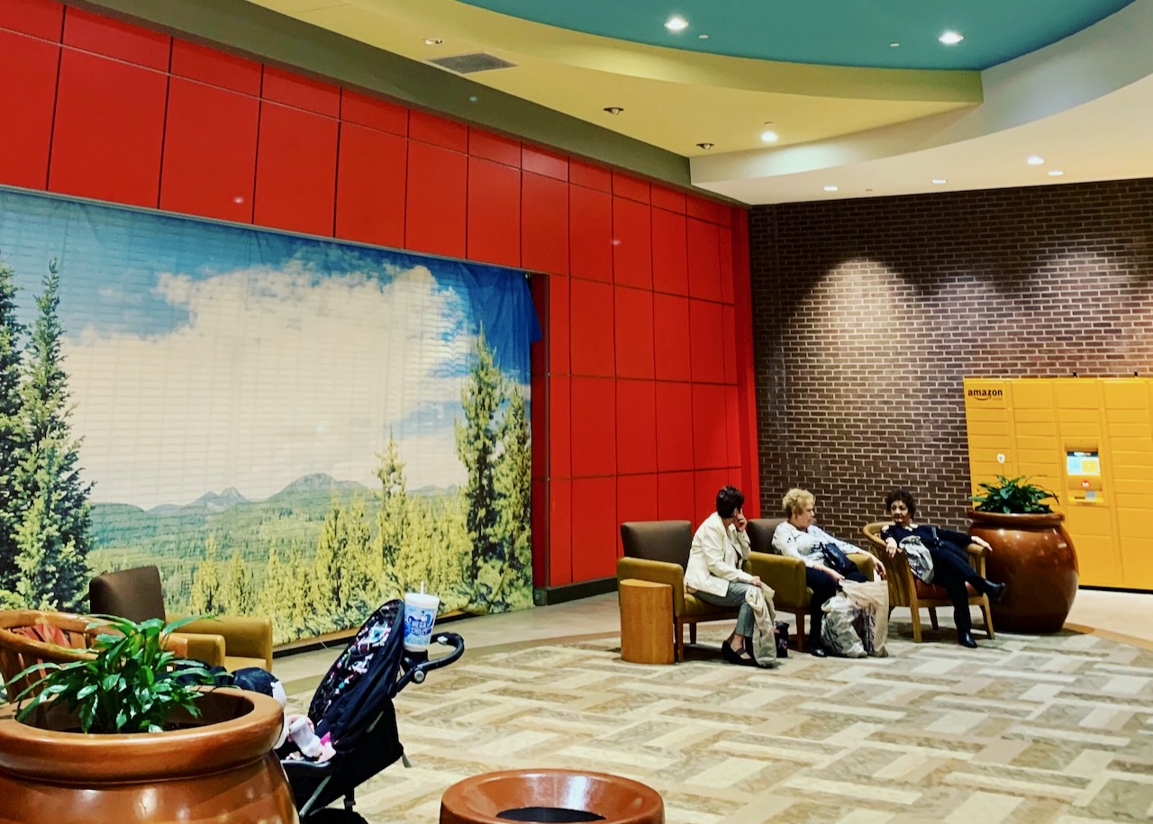 A colorful public lobby with red walls and yellow lockers.