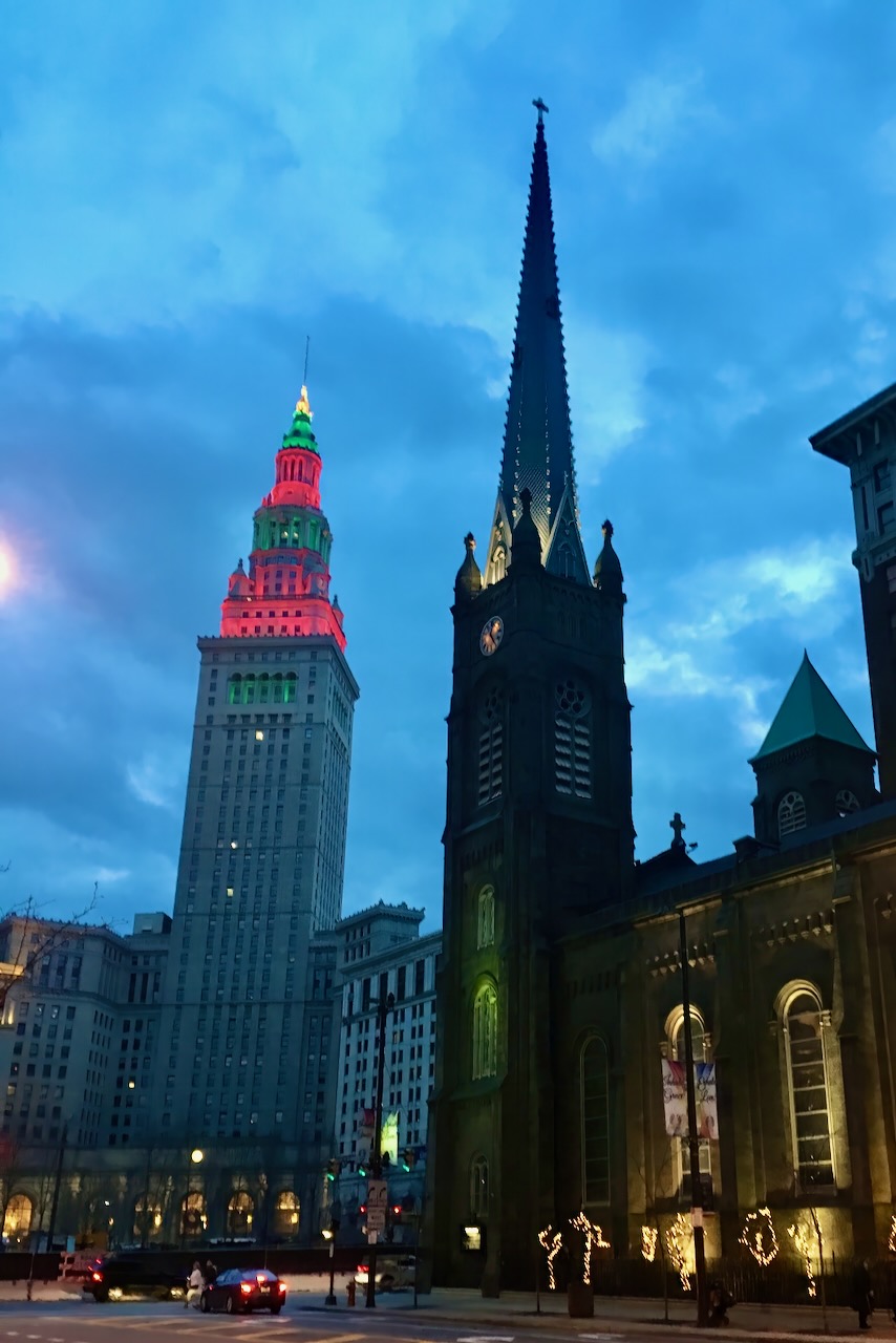 Downtown towers and a church spire at blue hour.