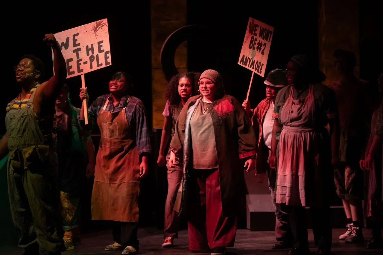 Final production angle showing the complete Urinetown scenic composition.
