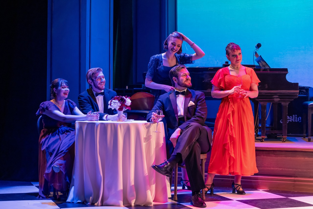 Actors framed by the cabaret environment.