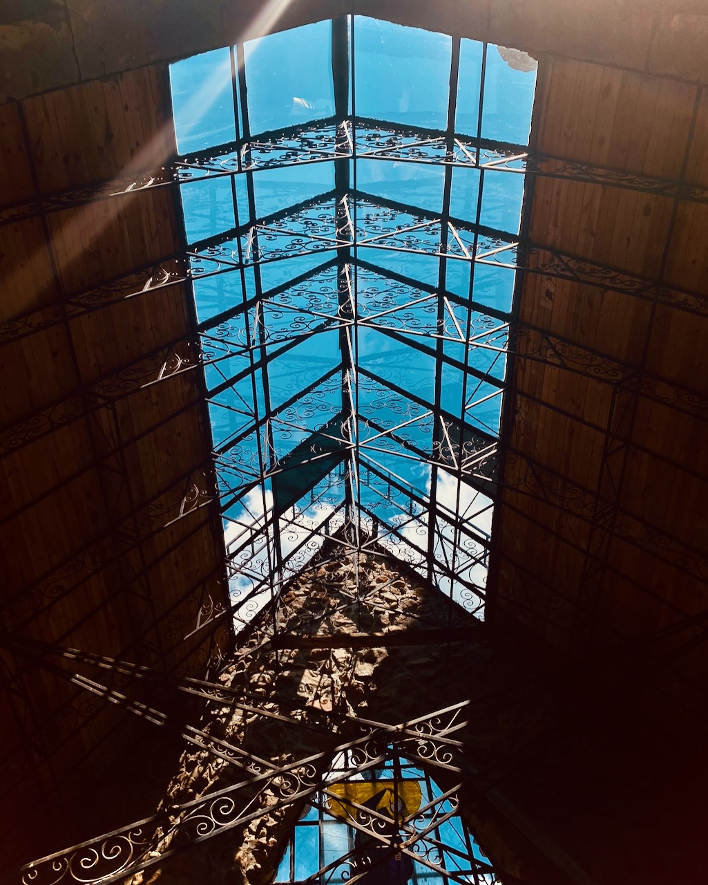 A blue glass skylight with ornate ironwork.