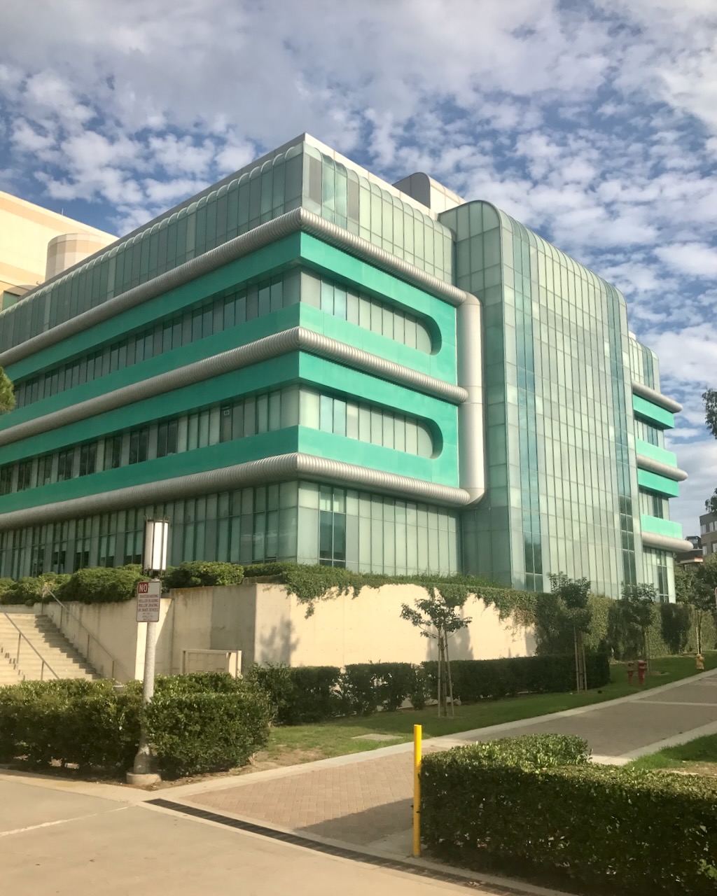 An aqua and glass building with rounded forms.