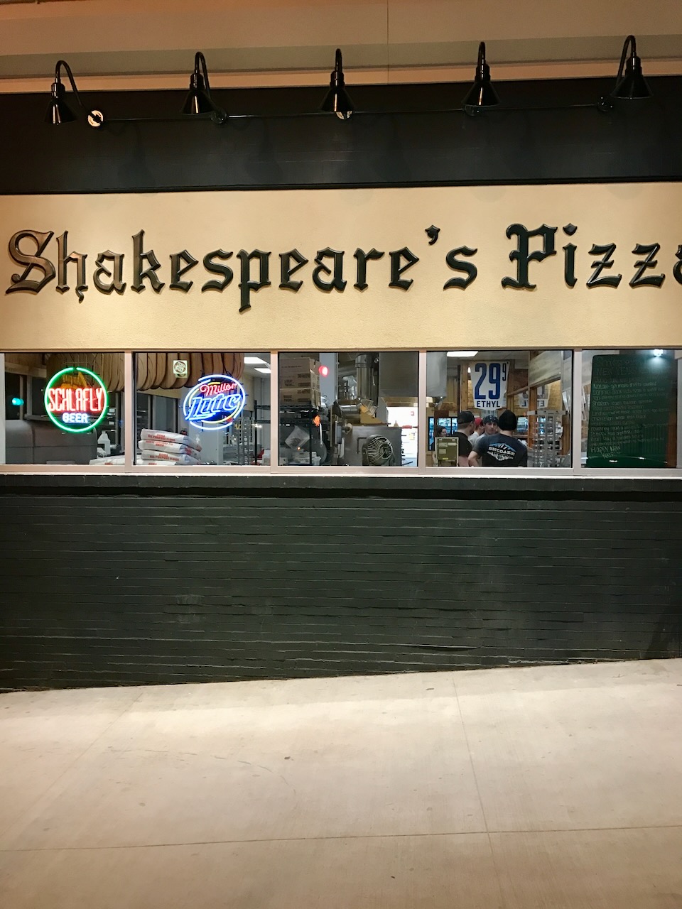 The Shakespeare's Pizza storefront at night.