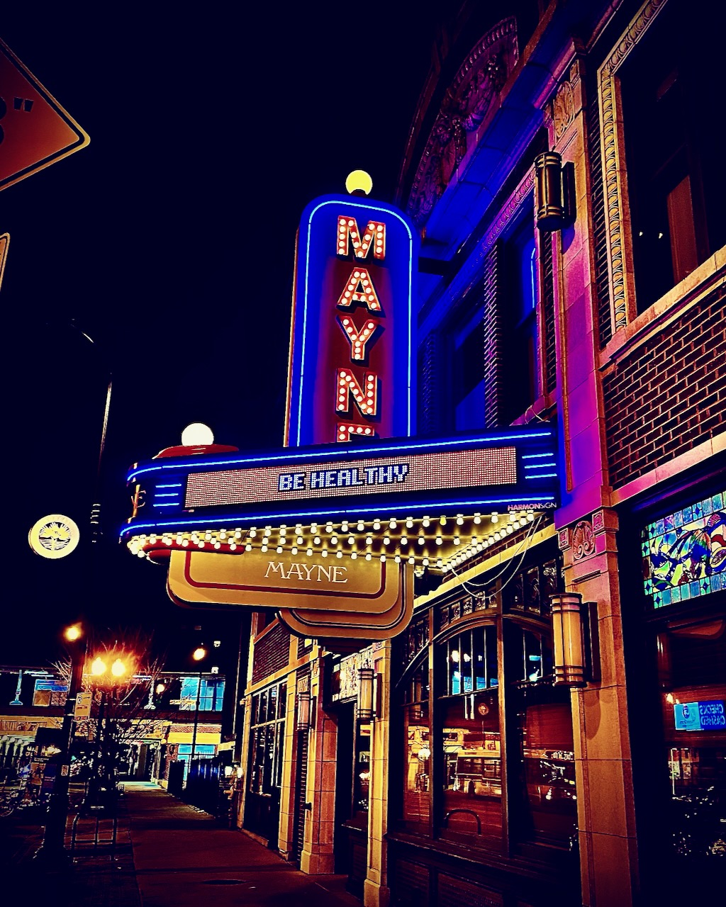 The Mayne theatre marquee glowing at night.