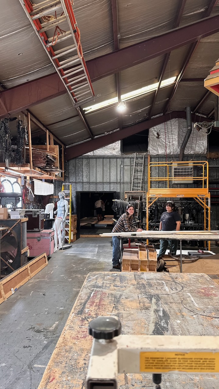 A scene shop with ladders, platforms, and lumber.