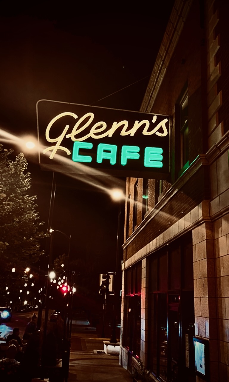 A glowing Glenn's Cafe sign at night.