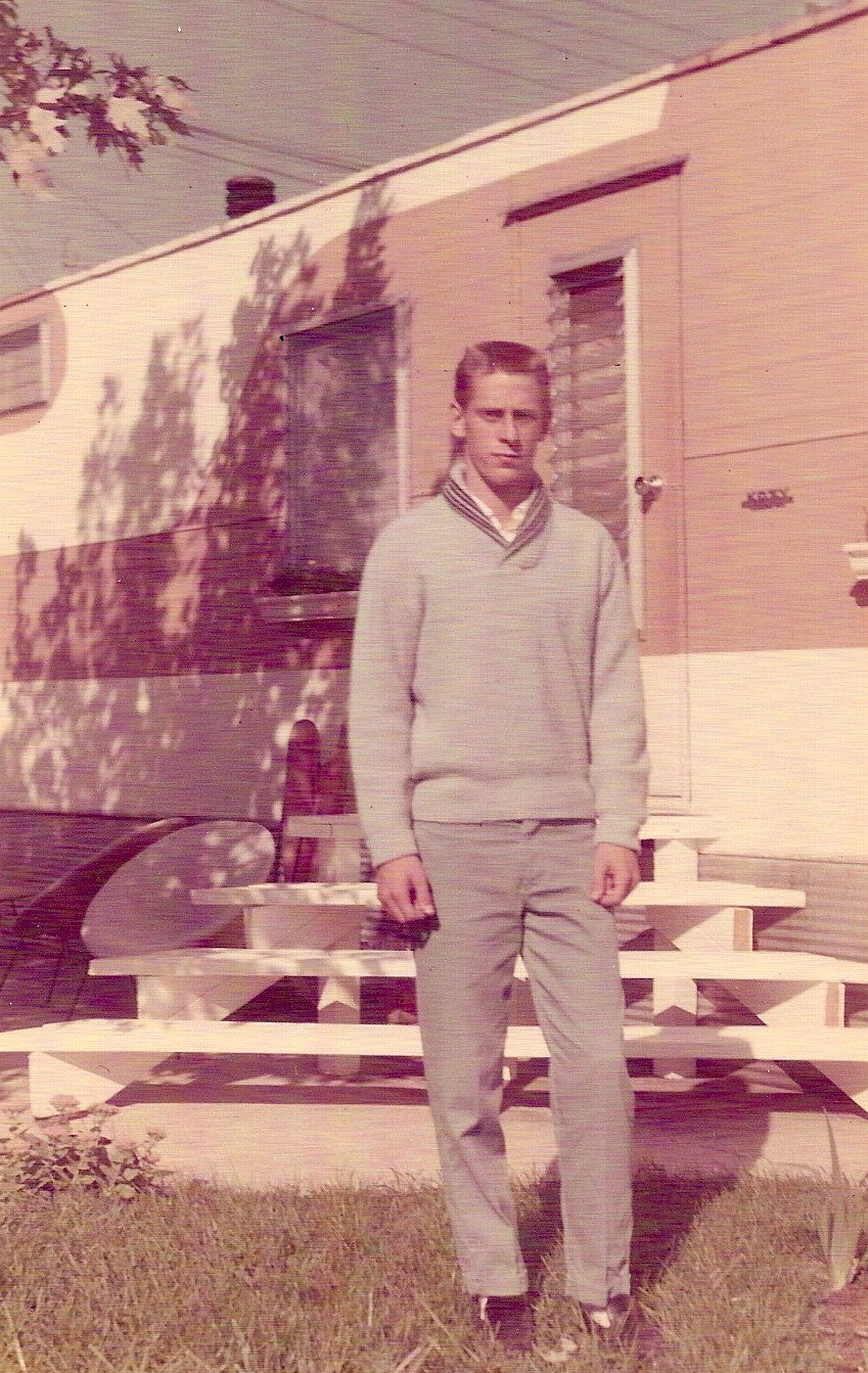 Young Dave stands in front of a trailer