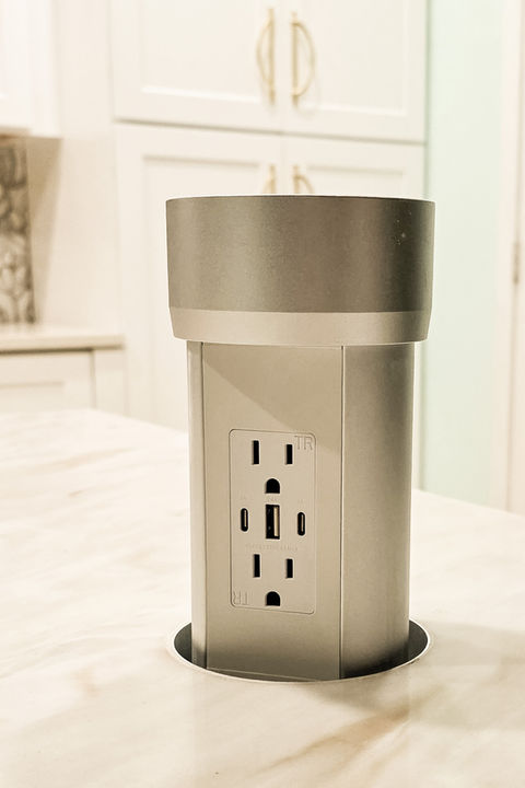 Kitchen pop-up outlet installed in countertop for cleaner everyday function