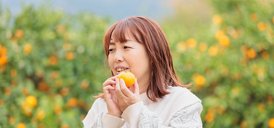 みかんを持って微笑む大人の女性