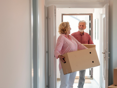 Seniors happily sorting belongings during downsizing process.