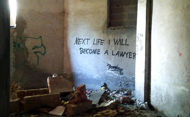 Graffiti stating "Next life I will become a lawyer" written on the wall and surrounded by ruins of the war-torn sniper tower in Mostar, Bosnia-Herzegovina