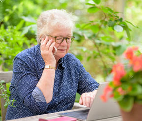Ældre dame modtager hjælp til sit internet på en bærbar computer