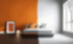 Schlafzimmer mit Bett. Die eine Seite des Zimmers ist orange gestrichen, die andere weiß.