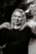 Woman laughing holding her glasses in hand.