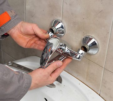 Plumber fixing faucet in a bathroom