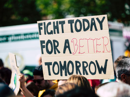 A cardboard sign at a rally that reads: fight today for a better tomorrow