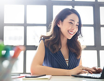 Smiling Person Typing On Laptop