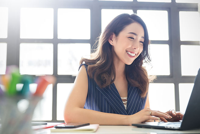Smiling Person Typing On Laptop
