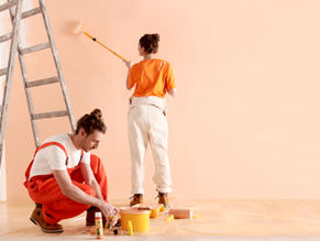 Two people painting their own room