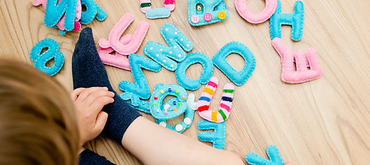Child Playing Letters in speech therapy, specific interests in speech therapy