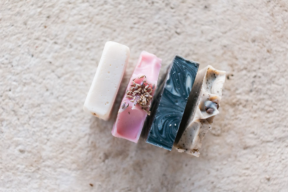 Four assorted handmade soap bars on a textured surface