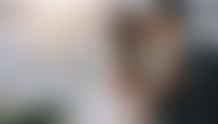 Un couple de mariés s'embrassant tendrement dans un domaine verdoyant lors d'une réception en extérieur, illustrant les tendances naturelles et intimistes des mariages 2026
