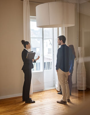 A real estate agent is showing a house to a young couple