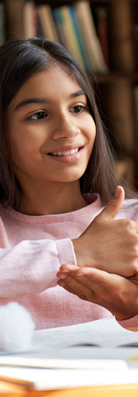 A young girl participating in a zoom speech therapy session at home. 